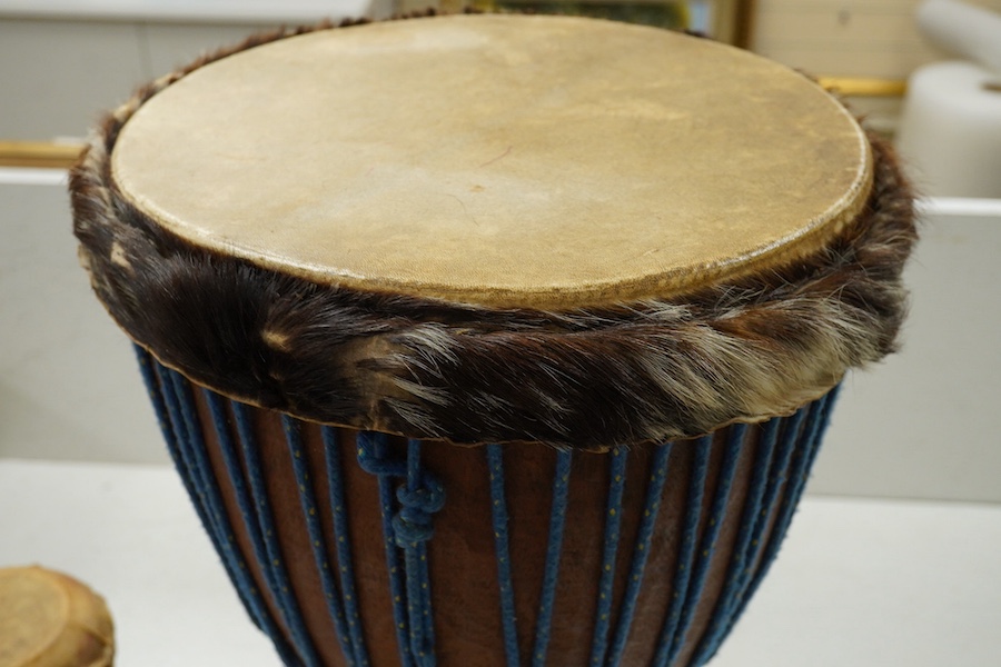 Five African drums; a Djembe, 60cm high, together with four small North African pottery double drums. Condition - fair to good.